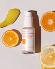 skincare bottle on white background with slices of orange placed around it.