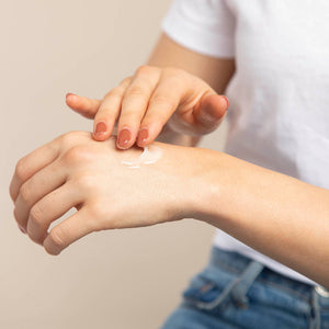 Woman applying Pear and lavender hand lotion product to back of hand