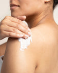 Women applying Bamboo Lemongrass BodyCrème to her shoulder.