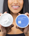 women holding open Bamboo Lemongrass Body Crème jar to show texture.
