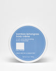 A container of Bamboo Lemongrass Body Crème by LATHER with a blue label on a white background.