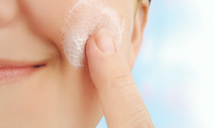 Close up image of woman applying product to cheek