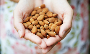 Woman holding raw almonds in her cupped hands