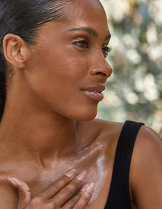 Woman applying moisturizer to her chest