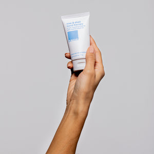 women holding rose and shea hand therapy cream in right hand