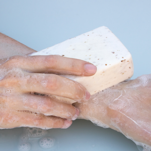 Close up of hands using sudsy Exfoliating Body Soap with Oatmeal & Bamboo Extract on forearm